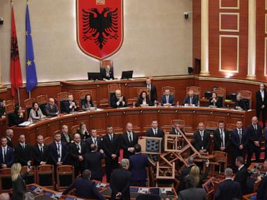 Albania’s opposition disrupts a budget vote with flares and piled-up chairs in Parliament